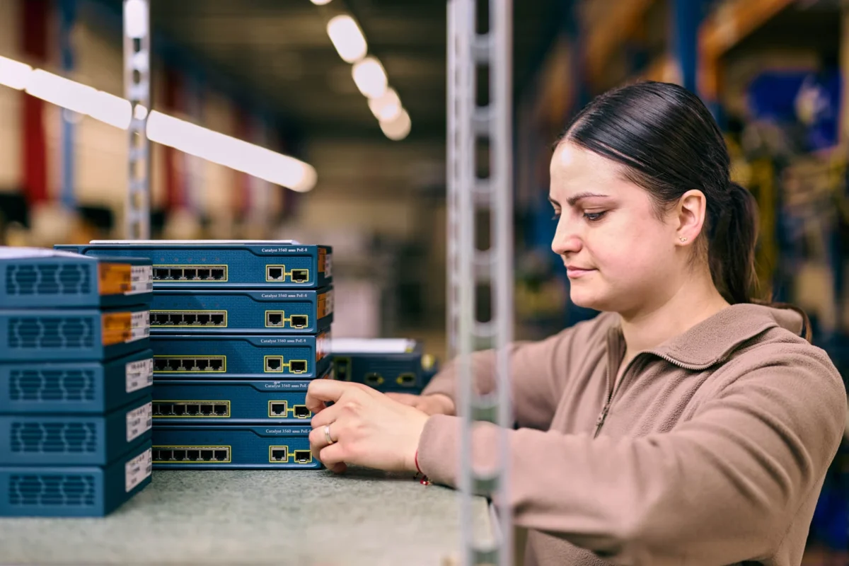 Technikerin sortiert Netzwerk-Switches im IT-Refurbishment Lager