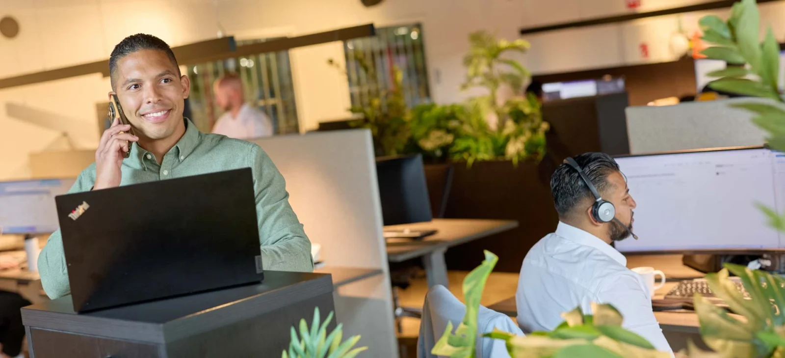 Employé commercial discutant de solutions informatiques tout en travaillant sur un ordinateur portable au bureau