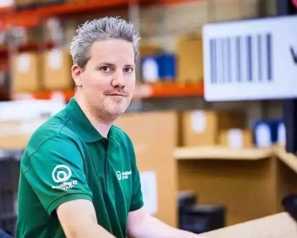 Employé de Circular IT group dans un environnement d’entrepôt avec poste de travail