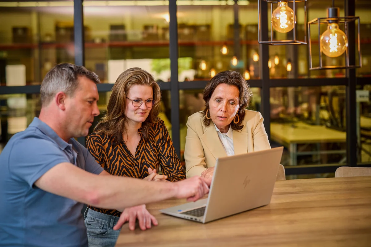 Zakelijk team bespreekt IT remarketing en refurbished hardware oplossingen op een laptop