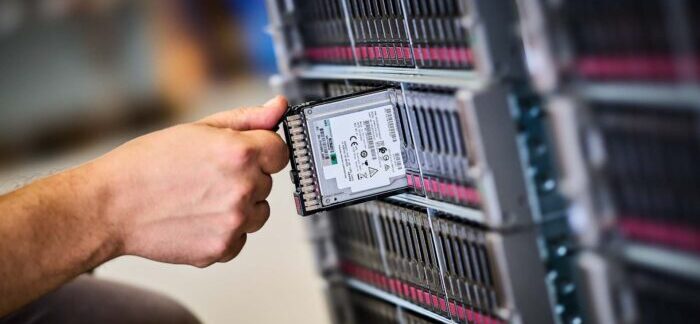 Close-up of an engineer removing enterprise storage during data centre decommissioning before secure IT asset recovery and reuse.