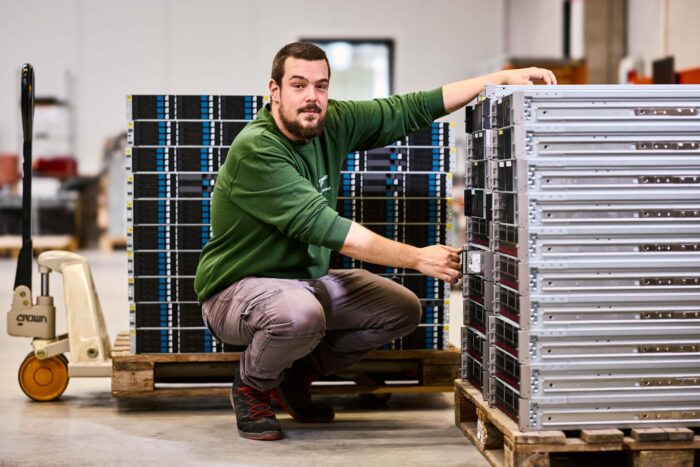 Engineer carrying out server decommissioning by removing enterprise storage hardware before secure IT asset disposition.